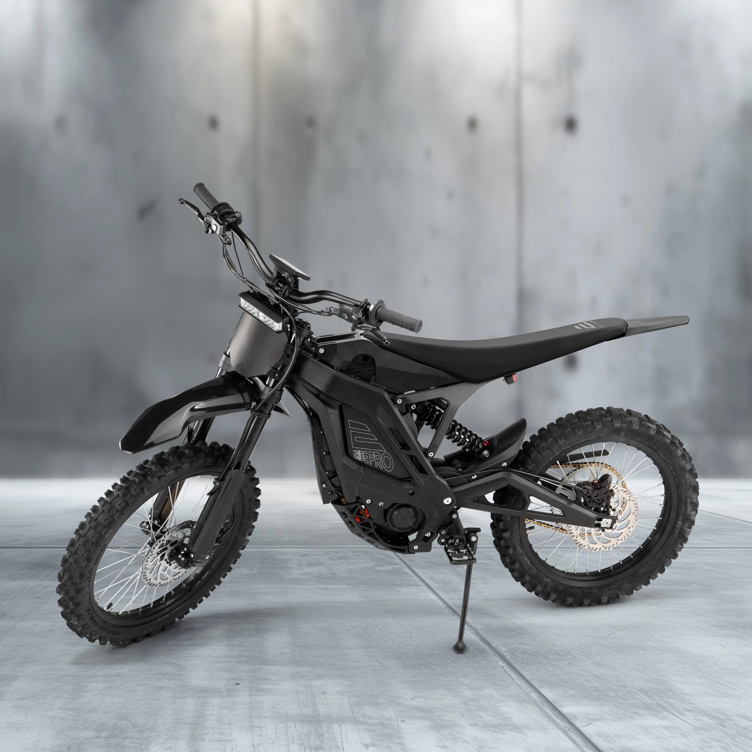 Black electric bike on a gray floor with a gray concrete wall background