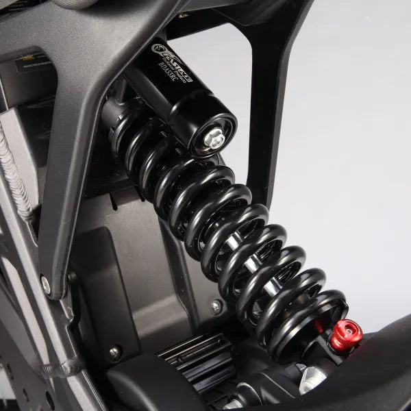 Close-up of a motorcycle suspension system with a shock absorber and visible brand logo.