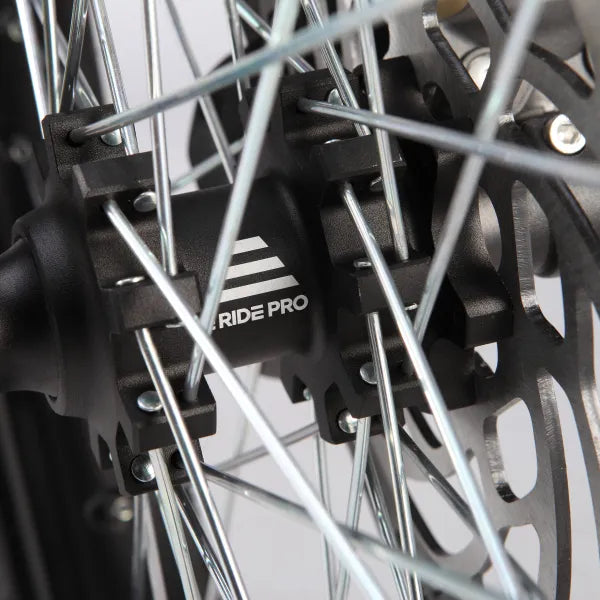 Close-up of a motorcycle wheel with 'RIDE PRO' branding on the brake rotor.